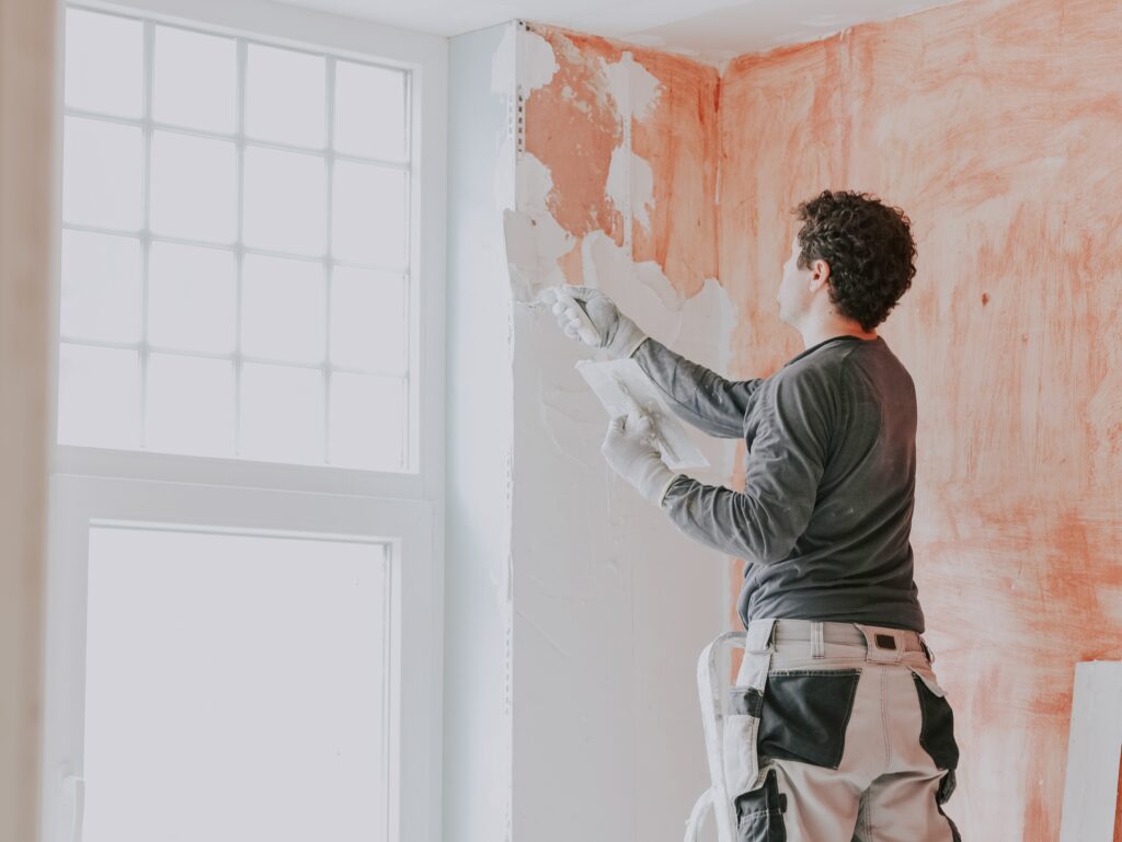 man smoothing plaster on wall during home renovati 2026 01 08 06 42 03 utc
